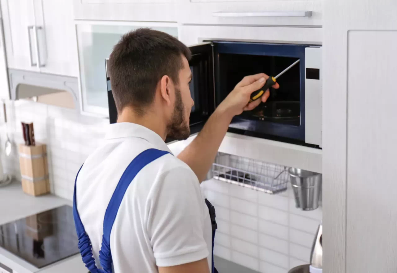 Fix Masters technician repairing microwave in South Florida kitchen